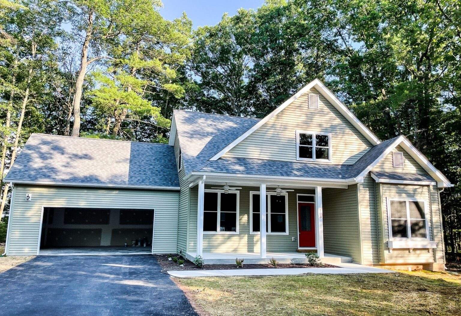 New custom home with sage green siding, white trim, a covered front porch and a two car garage near Winchester, VA