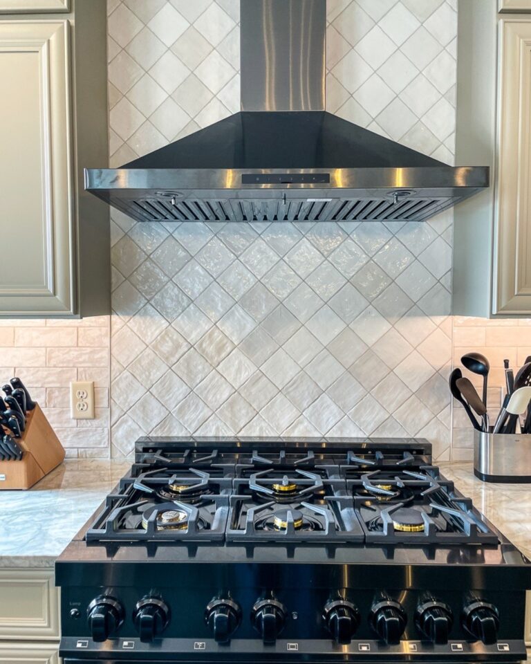 Professional gas range under a stainless hood with a cream tile backsplash, kitchen remodel in Winchester, VA