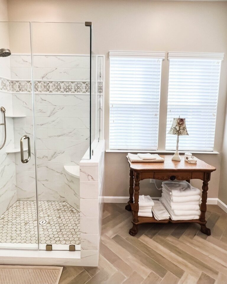 Marble look shower with a built in bench, glass door and patterned tile floor, bathroom remodel in Winchester, VA